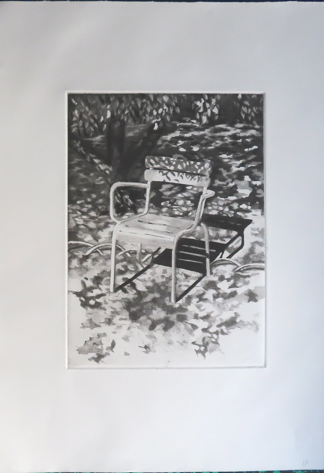 chaise en metal typique du jardin du luxembourg à l'ombre des arbres