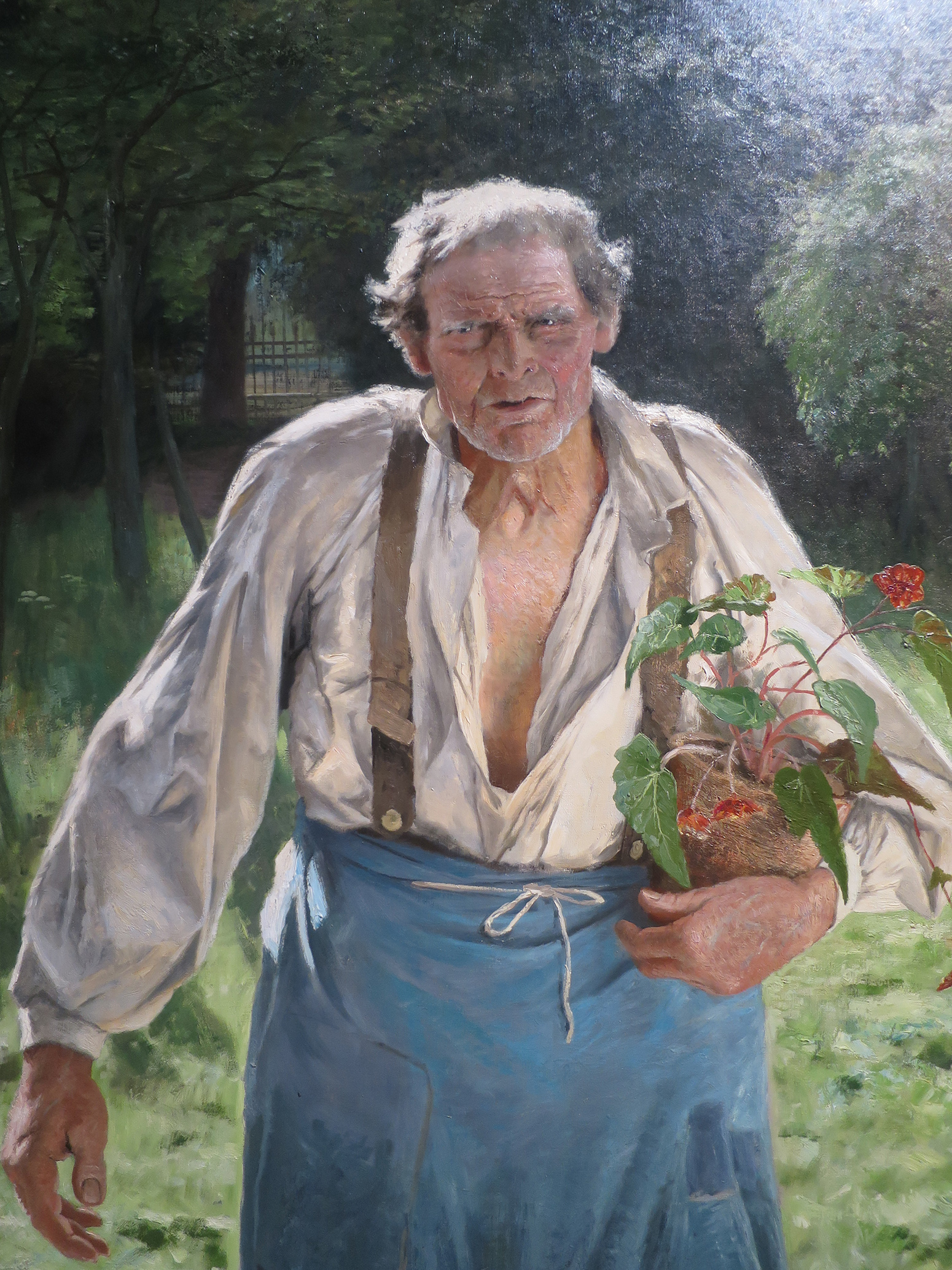 Homme âgé dans un jardin, un pot de fleur dans ses bras